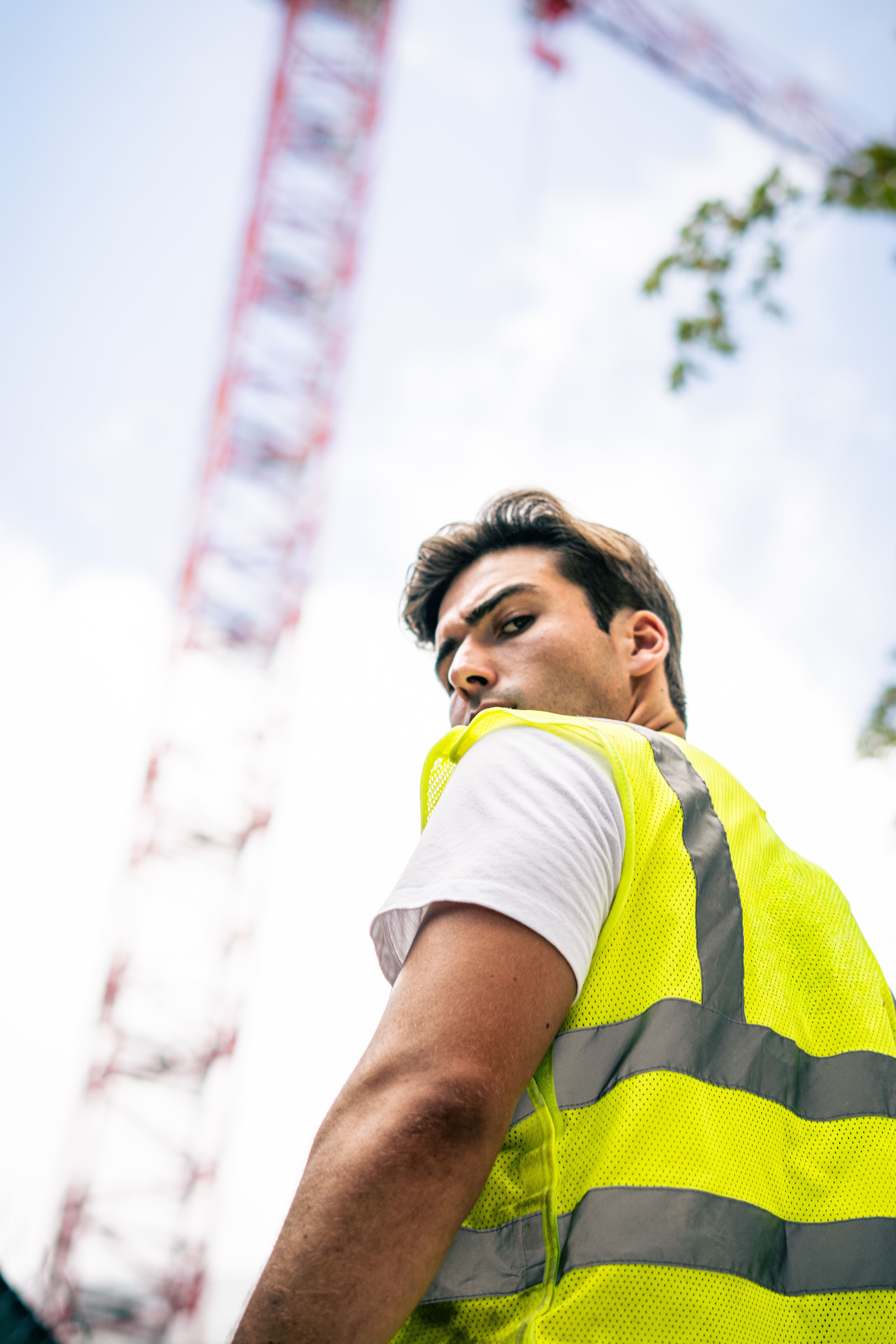Christian Utne in safety vest looking back with a construction crane behind